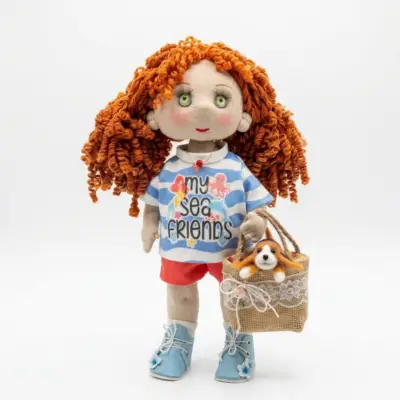 Handmade red-haired textile doll wearing a summer outfit and holding a decorative handbag with a miniature puppy inside.