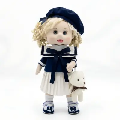 Handmade sailor fabric doll in navy suit with blonde curly hair holding a mini teddy bear by Art-Anna